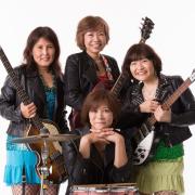 Four piece female beatles tribute band hips posing with instruments.